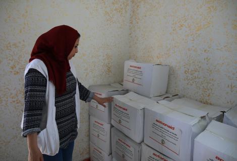 أحد المتطوعات من مركز الدراسات  النسوية ، الشريك لمؤسسة آكشن ايد-فلسطين  اثناء توزيع حصص غذائية في قطاع غزة ضمن التدخلات الطارئة للاستجابة لفيروس كورونا المستجد كوفيد-19  