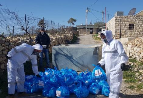 AAP''s staff members and volunteers participating in distributing medical protective equipment and hygiene kits on residents of Beit Skaria south-west Bethlehem  in the south of West Bank within AAP's efforts to respond to COVID -19  