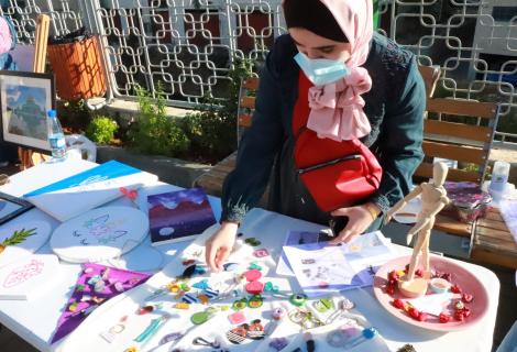 Photo of a young woman who is presenting her art and hand crafts products in “ Anqa Cultural Exhibition” supported by ActionAid Palestine to support the creativities of youth affected by COVID-19 in Hebron governorate in the South of West Bank- Palestine -Copy Rights of ActionAid Palestine 2020