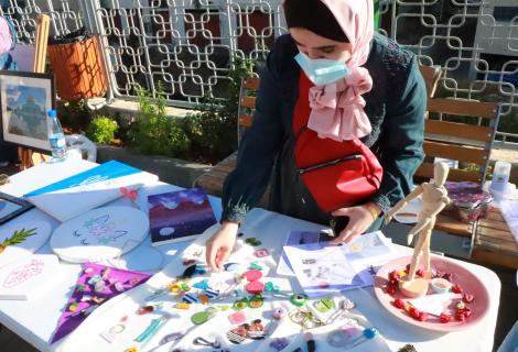 Photo of a young woman who is presenting her art and hand crafts products in “ Anqa Cultural Exhibition”  supported by ActionAid Palestine to support the creativities of youth affected by COVID-19 in Hebron governorate in the South of West Bank- Palestine -Copy Rights of ActionAid Palestine 2020 