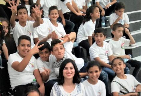 photo of Mai Al-Qaisi who was appointed “Save our Future” s Global Ambassador to Defend Right of Palestinian children to Education while she was implementing musical activities Palestine refugee children in Deheisha camp for refugees near Bethlehem -in the south of West Bank-Palestine 2020