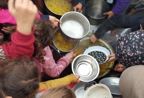 صورة لأطفال في قطاع غزة أثناء إصطفافهم للحصول على المساعدات الغذائية في مراكز الإيواء ومخيمات النزوح بعد التصعيد العسكري ضد قطاع غزة لعام 2023 \2024 
