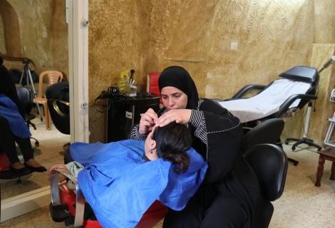 ورة نسرين أثناء عملها في مشروعها صالون النساء للتجميل المدعوم من قبل مؤسسة آكشن إيد فلسطين 