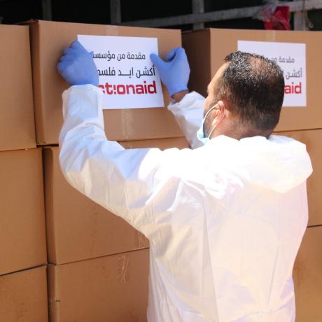 A young man is participating in preparing food parcels that will be distributed to the neediest families in the marginalized village “Karameh” in the south of Hebron governorate in the south of West Bank.