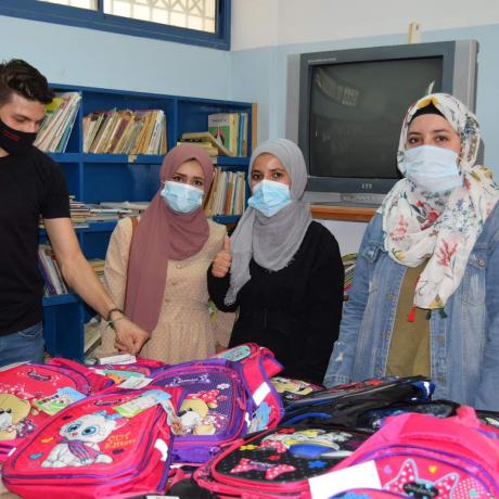 صورة للمتطوعين الشباب اثنا توزيع الحقائب المدرسية على المدارس في الأغوار 