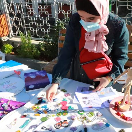 صورة شابة مشاركة وهي تعرض منتجاتها الفنية والحرفية في " معرض العنقاء الثقافي الذي دعمته مؤسسة أكشن ايد-فلسطين لدعم منتجات الشباب المتتضرين من جائحة كورونا في مدينة الخليل جنوب الضفة الغربية-فلسطين- الحقوق محفوظة لمؤسسة أكشن إيد-فلسطين -2020
